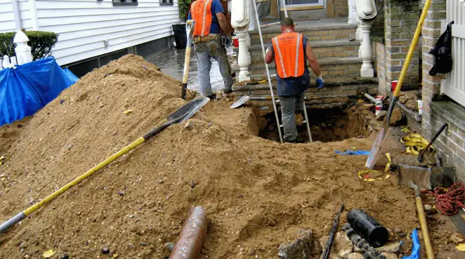 Contractors performing foundation protection and exterior drainage excavation near residential home steps in Minneapolis, MN